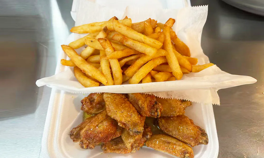 Seasoned chicken wings served with a side of crispy French fries at Kick Off Wings, a Fast Food Restaurant in Carrollton