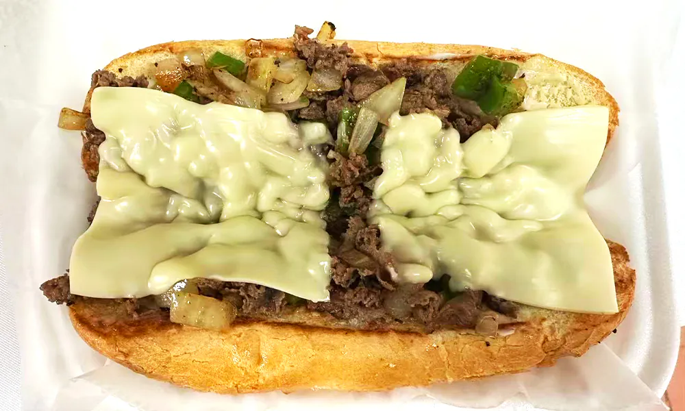 A Philly cheesesteak with beef, onions, peppers, and melted cheese at Kick Off Wings, a Fast Food Restaurant in Carrollton